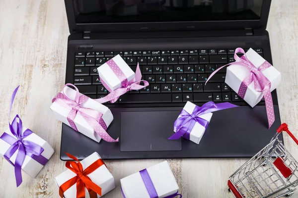 De nombreuses boîtes-cadeaux sur un ordinateur portable . — Photo