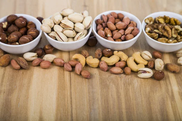 Nueces en un plato sobre una mesa de madera — Foto de Stock