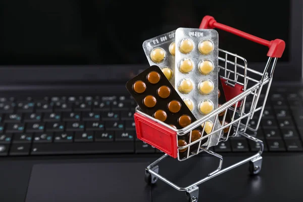 Bir dizüstü bilgisayarda haplarla alışveriş sepeti. 