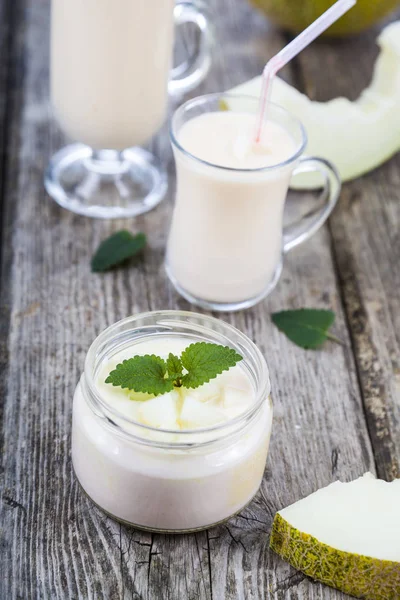 Yaourt et smoothie au melon sur une table en bois . — Photo