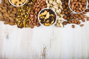 Ahşap bir masa üzerinde bir tabak içinde fındık.