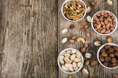 Ahşap bir masa üzerinde bir tabak içinde fındık. 