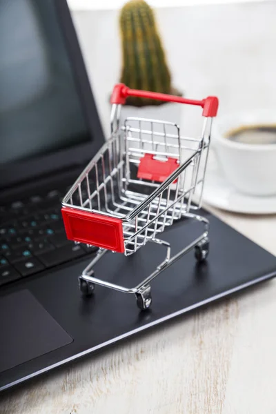 Cesta de compras en un ordenador portátil . — Foto de Stock