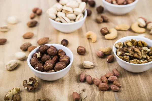 Ahşap bir masa üzerinde bir tabak içinde fındık. 