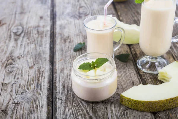 Yaourt et smoothie au melon sur une table en bois . — Photo