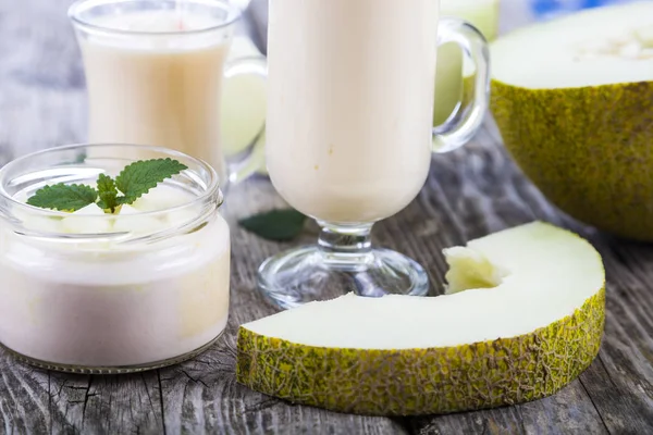 Yaourt et smoothie au melon sur une table en bois . — Photo