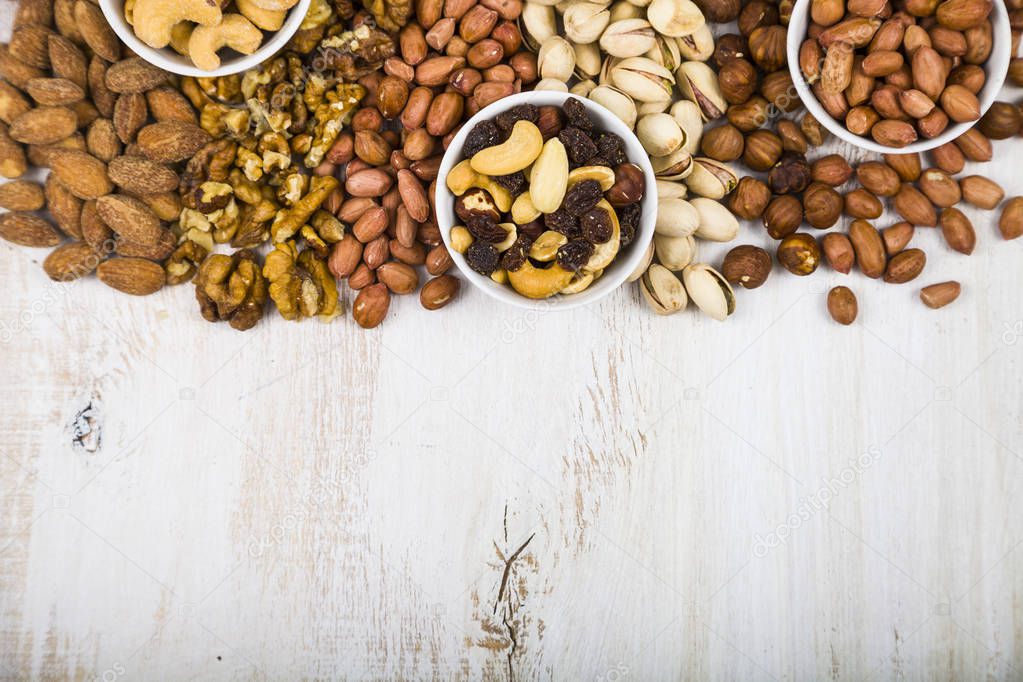 Nuts in a plate on a  wooden table.