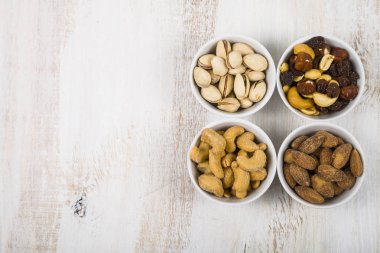 Ahşap bir masa üzerinde fındık ile dört kase.