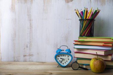 Renkli kalemler üzerinde bir yığın kitap üzerinde ahşap masa lambası
