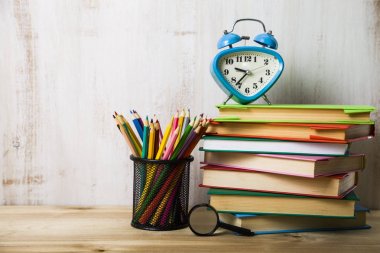 Bir yığın kitap üzerinde ahşap masa lambası çalar saat