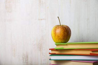 Okula dönüş. Bir yığın kitap ahşap masa lambası üzerinde elma