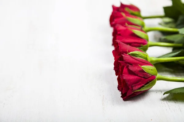 Czerwone róże na drewnianym tle — Zdjęcie stockowe