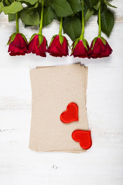 Rosa roja, corazones y papel para felicitaciones — Foto de Stock