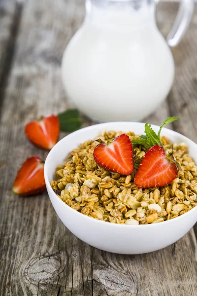 Granola with strawberry and a jug of milk — Stock Photo, Image