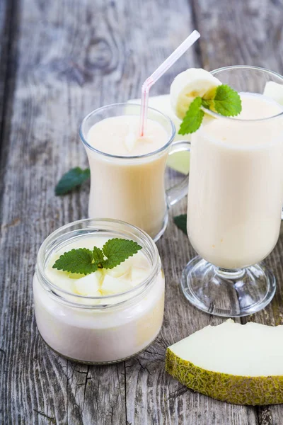 Yaourt et smoothie au melon sur une table en bois . — Photo