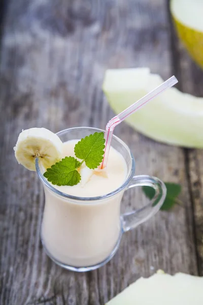 Iogurte e smoothie com melão em uma mesa de madeira . — Fotografia de Stock