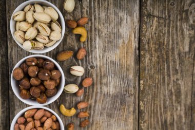 Ahşap bir masa üzerinde fındık ile beyaz kase