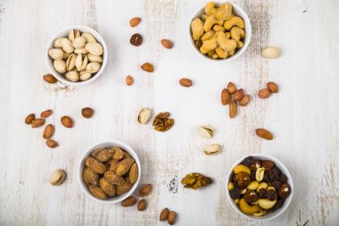 Ahşap bir masa üzerinde fındık ile dört kase