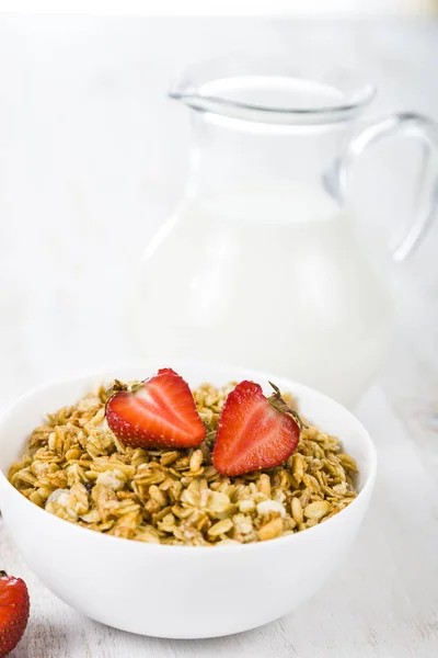 Granola with strawberry and a jug of milk — Stock Photo, Image