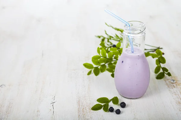 Smoothies und reife Blaubeeren auf einem Holztisch. — Stockfoto