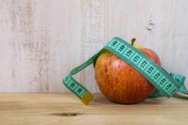 elma ve ahşap bir masa üzerinde ölçüm bandı.  