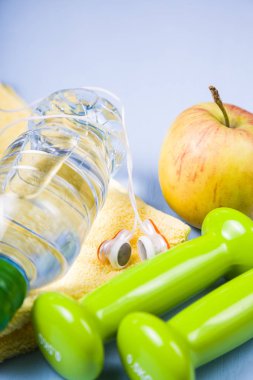 Halter, kulaklık ve bir şişe su ahşap bir masa üzerinde. 