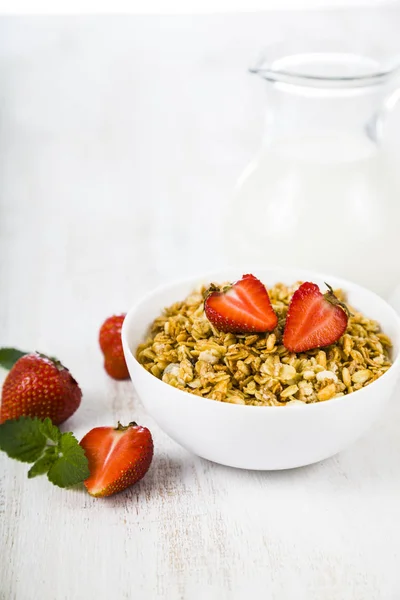 Granola with strawberry and a jug of milk — Stock Photo, Image