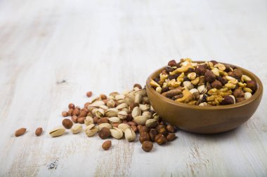 Ahşap bir masa üzerinde bir ahşap kase fındık 