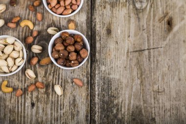 Ahşap bir masa üzerinde fındık ile beyaz kase