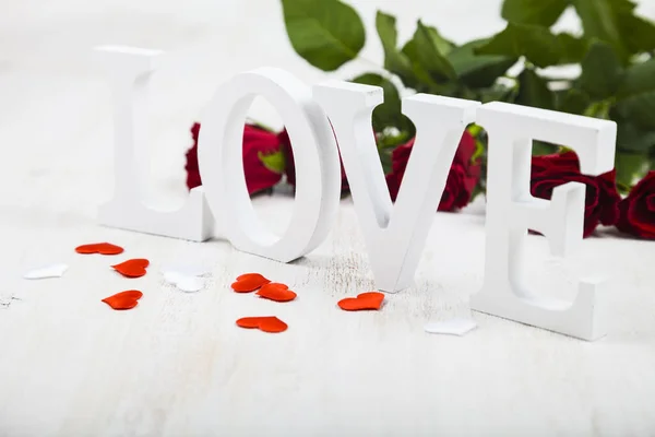 Червоні троянди і слово " Любов " — стокове фото