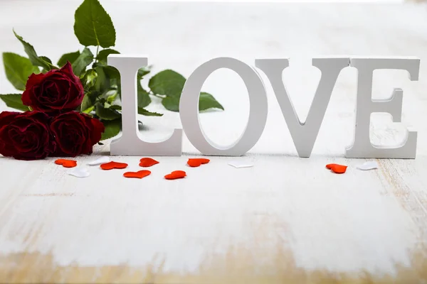 Röda rosor och ordet ”kärlek" — Stockfoto