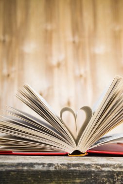 Tahta bir masanın üzerinde açık bir kitap  