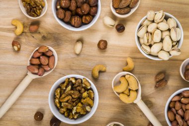 Ahşap bir masa üzerinde fındık ile dört kase