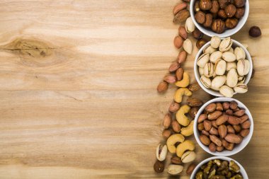 Ahşap bir masa üzerinde fındık ile dört kase