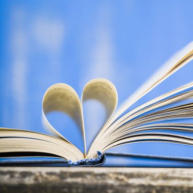 Tahta bir masanın üzerinde açık bir kitap  