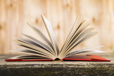 Tahta bir masanın üzerinde açık bir kitap  