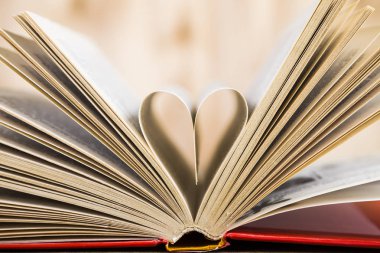 Tahta bir masanın üzerinde açık bir kitap  