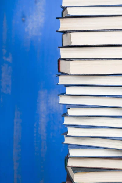 Pilha de livros em um fundo azul. — Fotografia de Stock