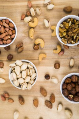 Ahşap bir masa üzerinde fındık ile dört kase