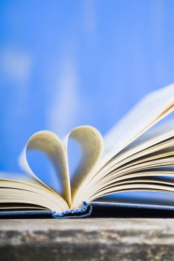 Tahta bir masanın üzerinde açık bir kitap  