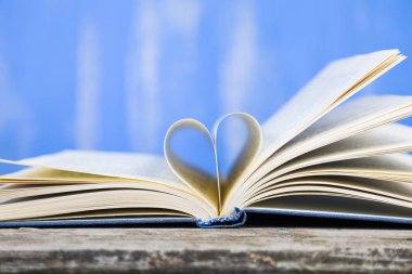 Tahta bir masanın üzerinde açık bir kitap  