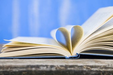 Tahta bir masanın üzerinde açık bir kitap  
