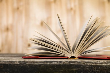 Tahta bir masanın üzerinde açık bir kitap  