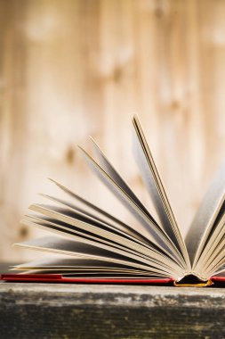 Tahta bir masanın üzerinde açık bir kitap  