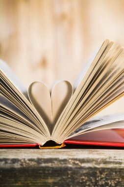 Tahta bir masanın üzerinde açık bir kitap  