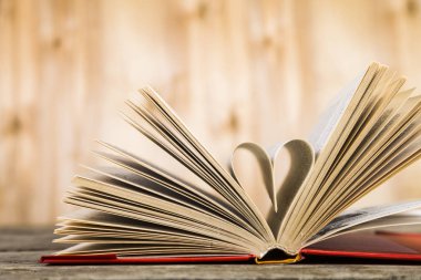 Tahta bir masanın üzerinde açık bir kitap  