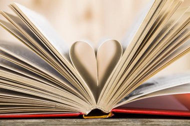 Tahta bir masanın üzerinde açık bir kitap  