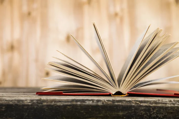 Tahta bir masanın üzerinde açık bir kitap  