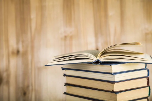 Pilha de livros em um fundo de madeira . — Fotografia de Stock