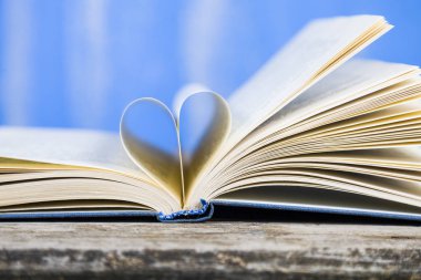 Tahta bir masanın üzerinde açık bir kitap  